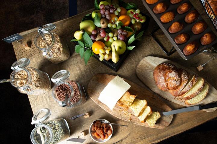 Desayuno gourmet en un apartahotel de la gama Collection, con frutas frescas, pan artesanal, pasteles, cereales y frutos secos.